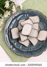 Traditional Malaysian Dessert Called Kuih Tepung Pelita Or Kuih Tako On A Rustic Plate Over A Dark Background. Coconut Milk And Flour Prepared In Banana Leaves. Popular During Fasting Month Ramadan