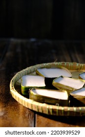 Traditional Malaysian Dessert Called Kuih Tepung Pelita Or Kuih Tako On A Rustic Plate Over A Dark Background. Coconut Milk And Flour Prepared In Banana Leaves. Popular During Fasting Month Ramadan