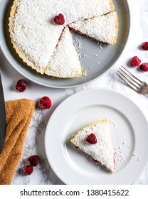 Traditional Manchester Tart On White Marble With Raspberries And Coconut