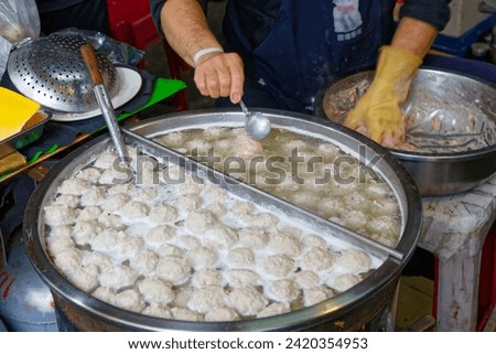 In a traditional marketplace in Yilan, Taiwan, a stall vendor selling handmade meat balls, fish-balls and shrimp-balls from fresh raw ingredient in a hot pot
