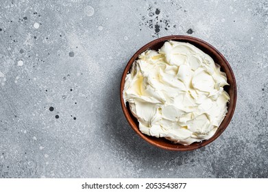 Traditional Mascarpone cheese in wooden bowl. Gray background. Top view. Copy space