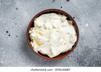 Traditional Mascarpone cheese in wooden bowl. Gray background. Top view