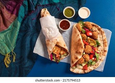 Traditional Mediterranean Arabic grilled halloumi and falafel, hummus and vegetables in flatbread wraps with herbs and a variety of sauces - Powered by Shutterstock