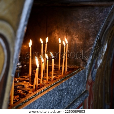 Traditional metal candle stand in the interior of Aghios Nikolaos Thalassinos a picturesque whitewashed Greek Orthodox basilica at the port of Aegina island, in Greece. 