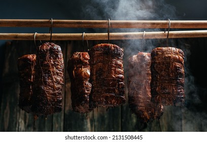 Traditional method of smoking meat in smoke. Smoked ham, bacon, pork neck and sausages in a smokehouse. - Powered by Shutterstock