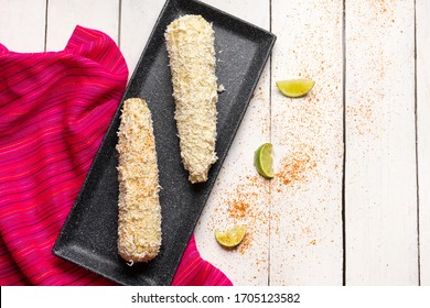 Traditional mexican boiled corn on the cob with mayonnaise and cheese on white background