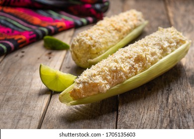 Traditional mexican boiled corn on the cob with mayonnaise and cheese on wooden background