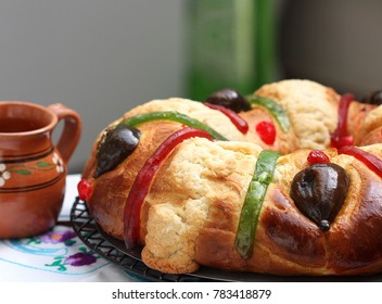 Traditional mexican bread, Rosca de Reyes, Kings cake with figs and sugar crust besides typical  clay cup.
