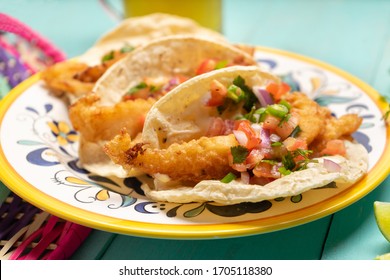Traditional mexican breaded fish tacos also called ensenada on turquoise background