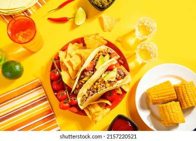 Traditional Mexican Corn Tacos With Meat, Vegetables, Avocado, Beans, Salsa And Nachos. Served With Various Sauces And Drinks. Top View. Big Family Gatherings. Copy Space