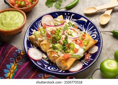 Tacos de patata frita mexicana tradicional llamados flautas con guacamol y queso