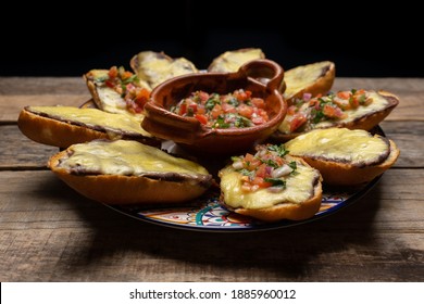 Molletas mexicanas tradicionales con queso y salsa fresca sobre fondo de madera