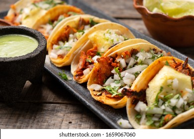 Traditional mexican pork tacos called "Al pastor" with pineapple on wooden background - Shutterstock ID 1659067060