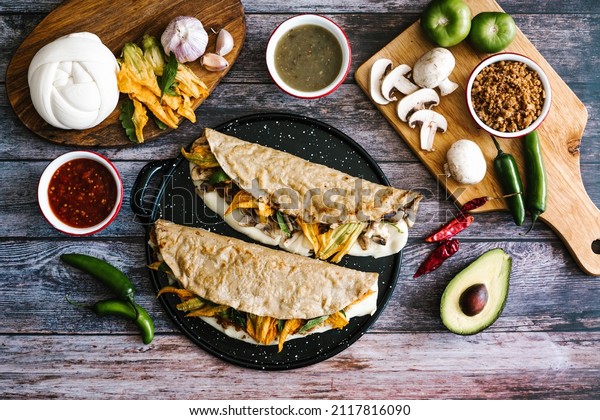 Traditional mexican quesadillas of chicharron or\
mushrooms, oaxaca cheese, squash blossom and epazote in corn\
tortillas in Mexico\
City