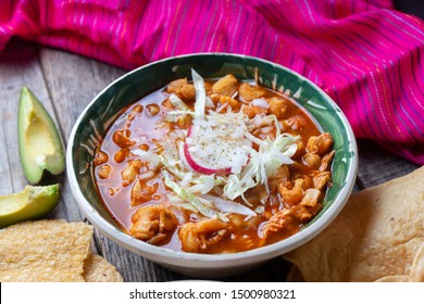 Traditional mexican red pozole soup on wooden background