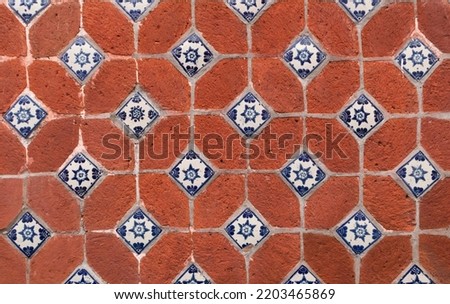 traditional mexican red wall  with blue details adornments of handmade hand painted talavera poblana tiles in Atlixco, Puebla city, Mexico
