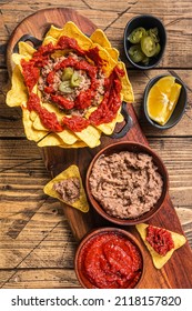 Traditional Mexican Refried Beans With Nachos, Jalapeno And Tomato Sauce. Wooden Background. Top View