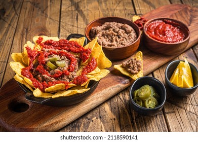 Traditional Mexican Refried Beans With Nachos, Jalapeno And Tomato Sauce. Wooden Background. Top View