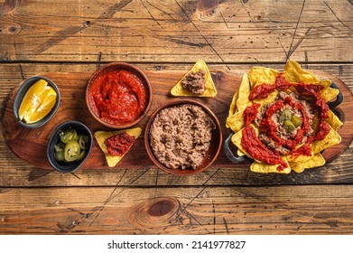 Traditional Mexican Refried Beans With Nachos, Jalapeno And Tomato Sauce. Wooden Background. Top View.