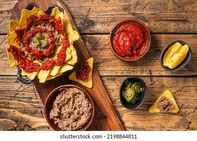 Traditional Mexican Refried Beans With Nachos, Jalapeno And Tomato Sauce. Wooden Background. Top View.