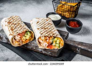 Traditional Mexican roll burritos with meat, vegetable salad and french fries. White background. Top view.
