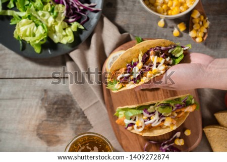 Traditional mexican taco with chicken and vegetables on wooden table. Latin american food. 