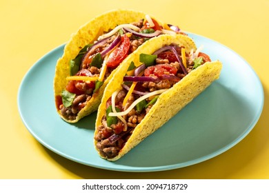 Traditional Mexican tacos with meat and vegetables on yellow background - Shutterstock ID 2094718729