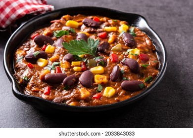 Traditional Mexican Tex Mex Chili Con Carne In Iron Pan On Black Stone Background