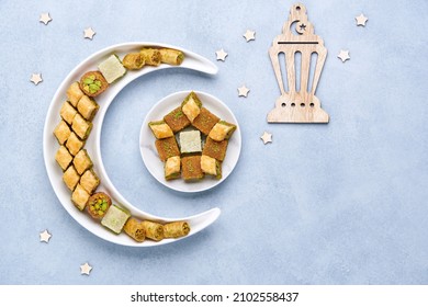 Traditional middle eastern dessert baklava in shape of moon and star . Ramadan background with sweets and lantern   , Top view, flat lay , copy space                          - Shutterstock ID 2102558437