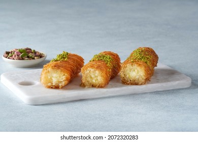 Traditional middle eastern sweets mabroma roll with cheeese and pistachio. Closeup, copy space                             