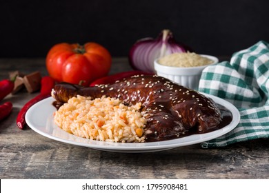 Traditional mole Poblano with rice in plate on wooden table