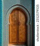 Traditional Moroccan ancient wooden entry door. In the old Medina in Chefchaouen, Morocco. Typical, old, blue intricately carved, studded, Moroccan riad door.