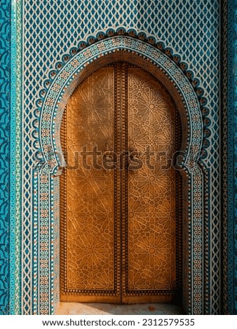 Traditional Moroccan ancient wooden entry door. In the old Medina in Chefchaouen, Morocco. Typical, old, blue intricately carved, studded, Moroccan riad door.