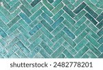 Traditional Moroccan tiles in a herringbone pattern, showcasing intricate craftsmanship and vibrant green hues, typical of Moroccan architectural design, perfect for a background or texture.