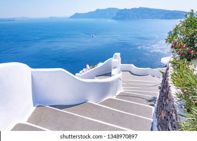 Traditional narrow street with stairs leading to the sea in Oia village, Santorini Island, Greece. Beautiful summer landscape, sea view - Powered by Shutterstock
