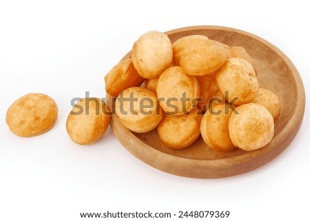 Traditional national Kazakh pastry Baursak in a wooden plate isolated on white. Cuisine of ancient nomads. Nauryz.