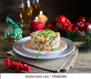 Tradizionale Capodanno e insalata di Natale in vacanza, su un piatto, inverno, natura morta di Capodanno con champagne e candele, vecchio sfondo in legno, rustico