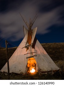 Traditional North American Teepee.  Illuminated By The Full Moon With A Fire Warming The Inside.