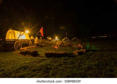 Traditional North American Teepee And People. Illuminated By Fire Camp