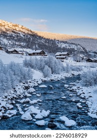 Traditional norwegen wooden houses on a river side covered in snow in Eidfjord village during sunset, Norway - Shutterstock ID 2296018929