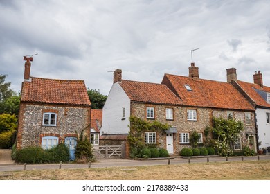Traditional old cottages line the main road in the pretty Norfolk coastal village of Burnham Market seen in July 2022.