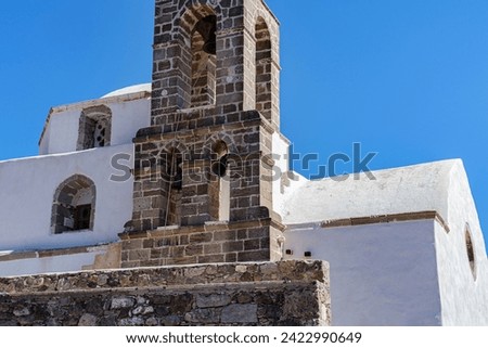 traditional old greek church architecture, stone and whitewashed construction with bell tower
