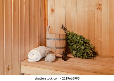 Traditional old Russian bathhouse SPA Concept. Interior details Finnish sauna steam room with traditional sauna accessories set basin birch broom towel aroma oil. Relax country village bath concept