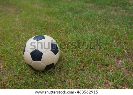 Traditional old soccer ball on green grass.football