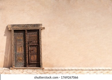 A traditional Omani Arabic wooden door, with solid wall. Copy space. Oman