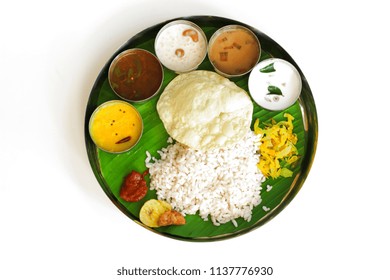 Traditional Onam Feast / South Indian  Vegetarian Thali On Banana Leaf And Round Steel Plate Isolated On White