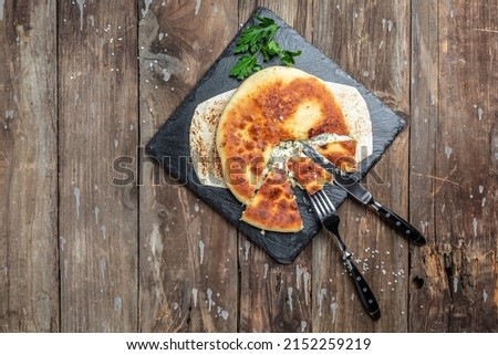 Traditional Ossetian feta cheese pie still life, with cheese, potatoes, herbs, cottage cheese, beef, mushrooms. National Caucasian dish, top view. Stock photo © 