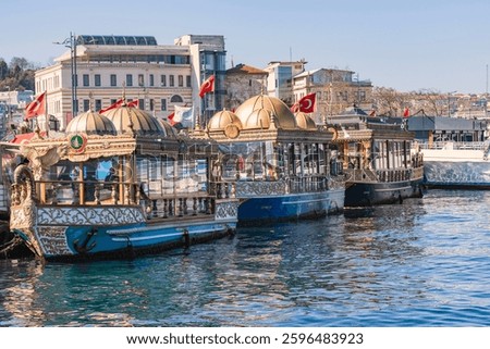 Traditional Ottoman-style boats docked at the waterfront in Istanbul, Turkey, serving as floating restaurants for famous Balık Ekmek (fish sandwiches), adorned with golden domes and Turkish flags.