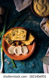 Traditional Paraguayan Food Known As Sopa Paraguaya On A Brown Ceramic Plate With Olives And Paraguayan Cheese Slices. Cornmeal, Eggs, Paraguayan Cheese, Onions And Onion Leaves As Ingredients.