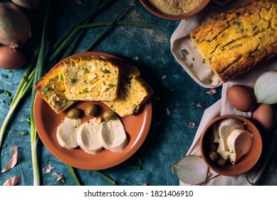 Traditional Paraguayan Food Known As Sopa Paraguaya On A Brown Ceramic Plate, With Cornmeal, Eggs, Onions, Onion Leaves And Paraguayan Cheese As Ingredients, Green Olives In The Plate As A Decoration.